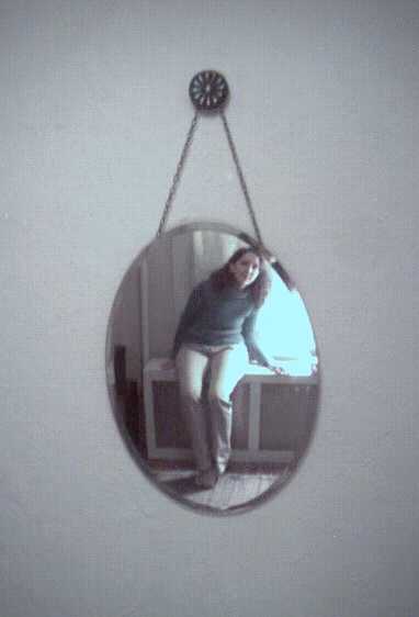 Wall mirror with teenager reflected in it